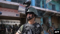 Pakistani soldiers patrol at an empty bazaar during a military operation against militants in the main town of Miran Shah in North Waziristan on July 9, 2014.