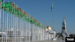 A view of the Arch of Neutrality monument on a street in central Ashgabat lined with national flags in 2006. Erected in 1998, the arch was moved to the suburbs of the capital in 2010.