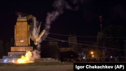 Activists dismantle Ukraine's biggest monument to Lenin, in the central square of the eastern city of Kharkiv, on September 28, 2014.