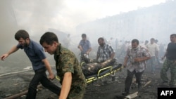 Volunteers carry a victim from the site of an explosion at a police compound in Nazran on August 17.