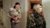 Женщина-заключенная с ребенком направляется на тюремное богослужение. Донецк, 17 декабря 2014 года