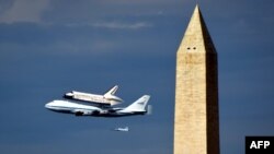 Discovery i ngarkuar mbi aeroplanin Boeing 747 fluturon afër Monumentit Uashington