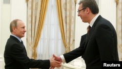 Russian President Vladimir Putin (left) greets Serbian Prime Minister Aleksandar Vucic during the latter's visit to Moscow in May, not long after Serbia's parliamentary elections. 