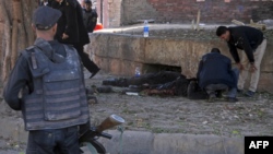 Egyptian security forces check casualties at the site of a bomb attack next to a police checkpoint in Cairo on December 9. 