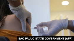 Медицинский работник получает вакцину от COVID-19, произведенную китайской Sinovac Biotech, в больнице Сан-Лукас в Порту-Алегри, на юге Бразилии. Август 2020.