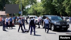 Сотрудники полиции задерживают человека после нападения в центре Алматы. 18 июля 2016 года.