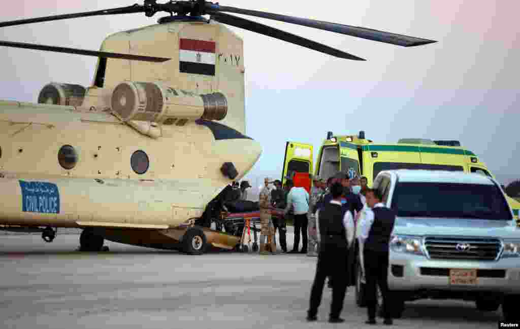 Египетские солдаты выгружают тела погибших из военного вертолета