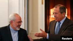 Russian Foreign Minister Sergei Lavrov (right) shows the way to Iranian counterpart Javad Zarif during a meeting in Moscow in August 2014.