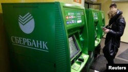 Russia -- People use an automated teller machine inside a branch of Sberbank in St. Petersburg, November 5, 2014