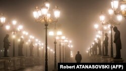 A man walks over a bridge through dense fog and smog in Skopje (file photo)