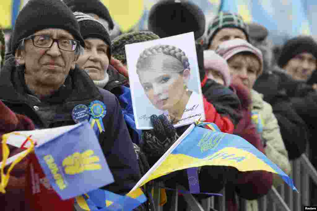A pro-EU protester holds a portrait of jailed opposition leader Yulia Tymoshenko.