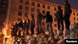 Үкіметке қарсы шерушілер баррикадаға шығып тұр. Киев, 23 қаңтар 2014 жыл.
