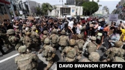 Membri Gărzii Naționale îngenunchează, în semn de respect pentru protestele antirasiale, Hollywood, California, 2 iunie 2020. 