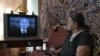 Възрастна жена от южния руски град Ставропол гледа телевизионно предаване с президента Владимир Путин, който отговаря на въпроси на народа.