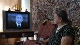 Възрастна жена от южния руски град Ставропол гледа телевизионно предаване с президента Владимир Путин, който отговаря на въпроси на народа.