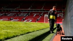 Pamje e policit me qen nuhatës në stadiumin Old Trafford pasi u evakuuan shikuesit për shkak të pakos së dyshuar