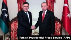 Türkiýäniň prezidenti Rejep Taýyp Erdogan (sagda) we Liwiýanyň premýer-ministr Faýez Sarraj (arhiw suraty)