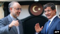 Eýranyň daşary işler ministri Ali Akbar Salehi (çepde) özüniň türkiýeli kärdeşi Ahmet Dawutoglu bilen. Ankara. 7-nji awgust, 2012 ý.