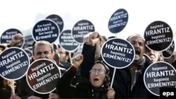 People hold signs reading :We are all Armenian, we are all Hrant" during a rally to mark the eighth anniversary of his murder in front of the Agos newspaper in Istanbul on January 19.