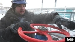 A worker adjusts a valve at a Gazprom gas field.