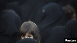 Девочка вместе со взрослыми женщинами участвует в религиозной церемонии в Тегеране. Иллюстративное фото.