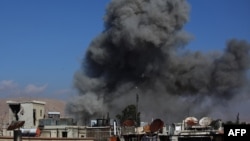 Дим піднімається від будівель після авіаудару урядових військ на місто Дума, 23 грудня 2014 року