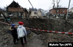 Діти дивляться на воронку після російського ракетного обстрілу. Село Солонка, Львівська область, 16 листопада 2022 року