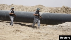 Polis İraqın Bəsrə əyalətində neft kəməri boyunca patrul çəkir.