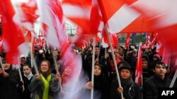Россия - Члены прокремлевской молодежной организации 'Наши' несмотря на дождь несут свои флаги во время митинга, посвященного Дню народного единства. 4 ноября 2010 г.