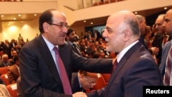 Iraqi Vice President Nuri al-Maliki (left) and new Prime Minister Haidar al-Abadi shake hands during the session to approve the new government in Baghdad in September 2014.