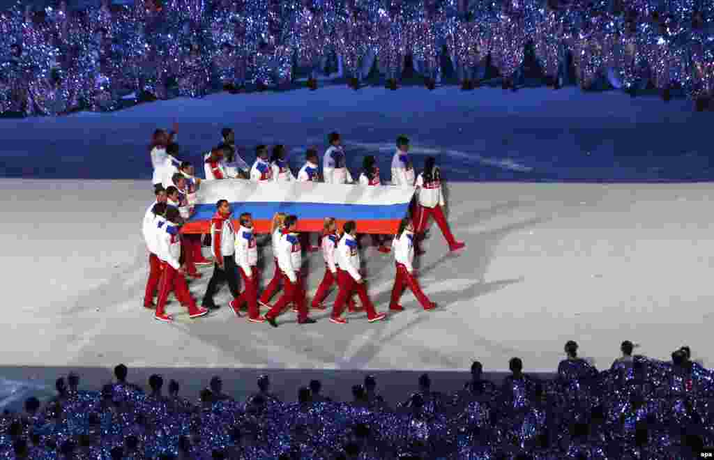 The Russian flag is carried into the stadium. (EPA/Barbara Walton)