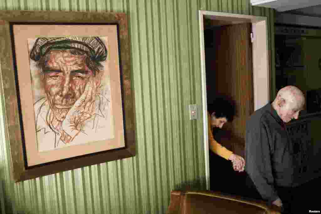 Alejandro Kirchuk of Argentina won a prize for his series &quot;Never Let You Go.&quot; Both in their late 80s, Marcos leads Monica, who is suffering from Alzheimer&#39;s, from their bedroom to the living room. 