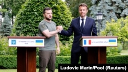 Ukrainian President Volodymyr Zelenskiy (left) shakes hands with French President Emmanuel Macron in Kyiv in June.