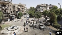 SYRIA -- Syrians gather to inspect the damage at the site of a suicide bomb attack in the capital Damascus' eastern Tahrir Square district, on July 2, 2017.