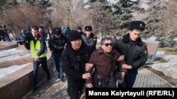 Полицейские уводят женщину, пришедшую на площадь Астана. Алматы, 22 февраля 2020 года.