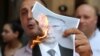 Учасник мітингу в столиці Грузії спалює фотографію президента Росії Володимира Путіна. Тбілісі, 20 червня 2019 року