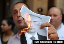 Участники протеста в Тбилиси сжигали портреты президента России Владимира Путина. Грузия, 20 июня 2019 года