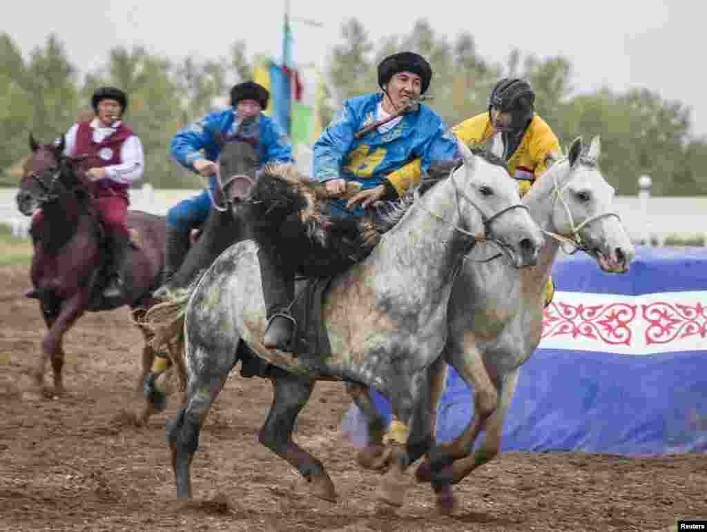 Riders from the teams from Kazakhstan (blue) and Tajikistan (yellow) compete in a match in Astana on September 11, 2013.