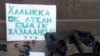 Алматы калаасынын борбордук аянтындагы "Калкка от аткан бийлик жазалансын" деген көрнөк. 6-январь, 2012-жыл