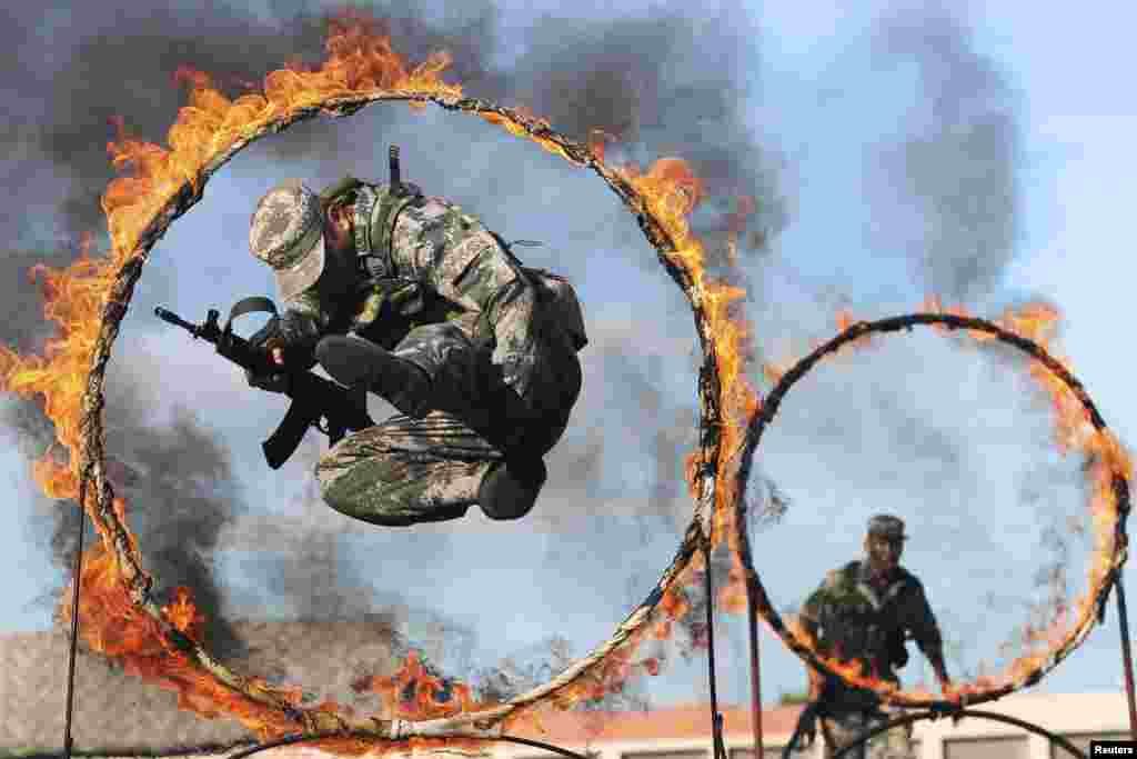 Soldiers from the Chinese People's Liberation Army jump through rings of fire as part of training during the PLA Army Day in Wenzhou, Zhejiang Province. (Reuters/Stringer)
