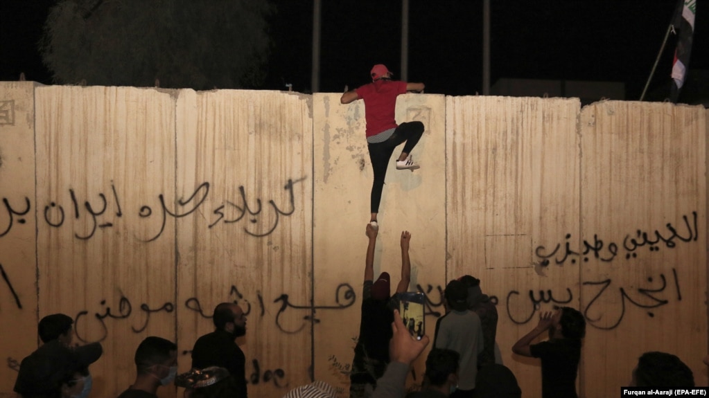 Un manifestant irakien tente d'escalader le 3 novembre le mur de béton du consulat d'Iran à Karbala.