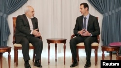 Syrian President Bashar al-Assad (right) meets with Iranian Foreign Minister Mohammad Javad Zarif in Damascus on January 15.