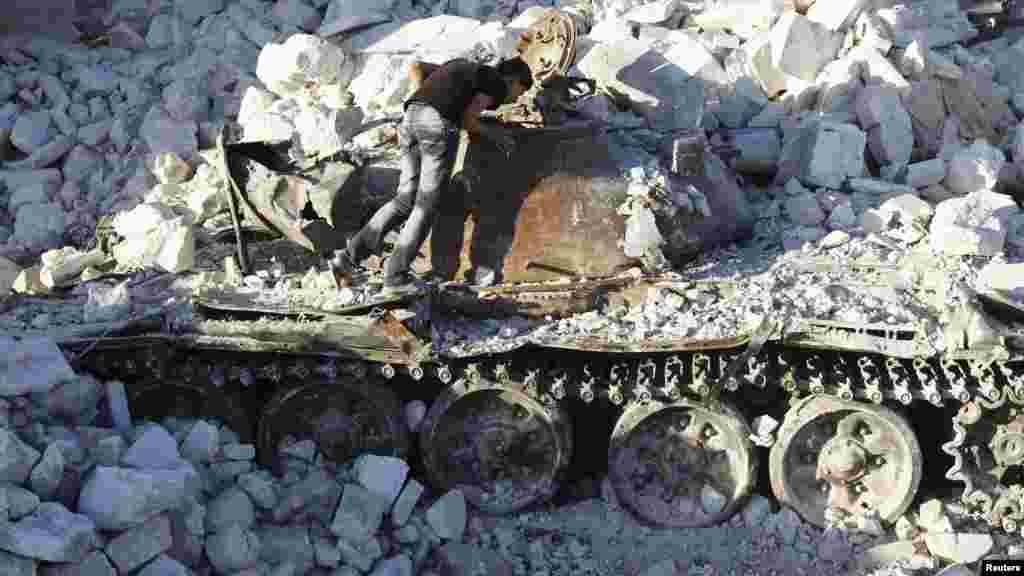 A man inspects a destroyed Syrian Army tank in Azaz, some 47 kilometers north of Aleppo on August 3. (REUTERS/Goran Tomasevic)