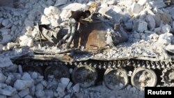 A man inspects a destroyed Syrian Army tank in Azaz, some 47 kilometers north of Aleppo.