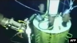 This still image from a live BP video shows the cap being lowered.