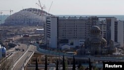 The Fisht Olympic stadium (L) and a mosque (R, front) are seen under construction in Sochi, the host city for the Sochi 2014 Winter Olympics, 24Apr2013
