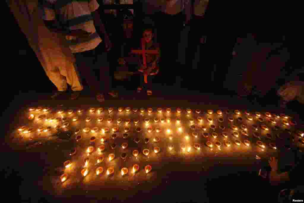 Members of the Christian community in Lahore light oil lamps during a protest rally to condemn a suicide attack on a church in Peshawar that left dozens dead. (Reuters/Mohsin Raza)