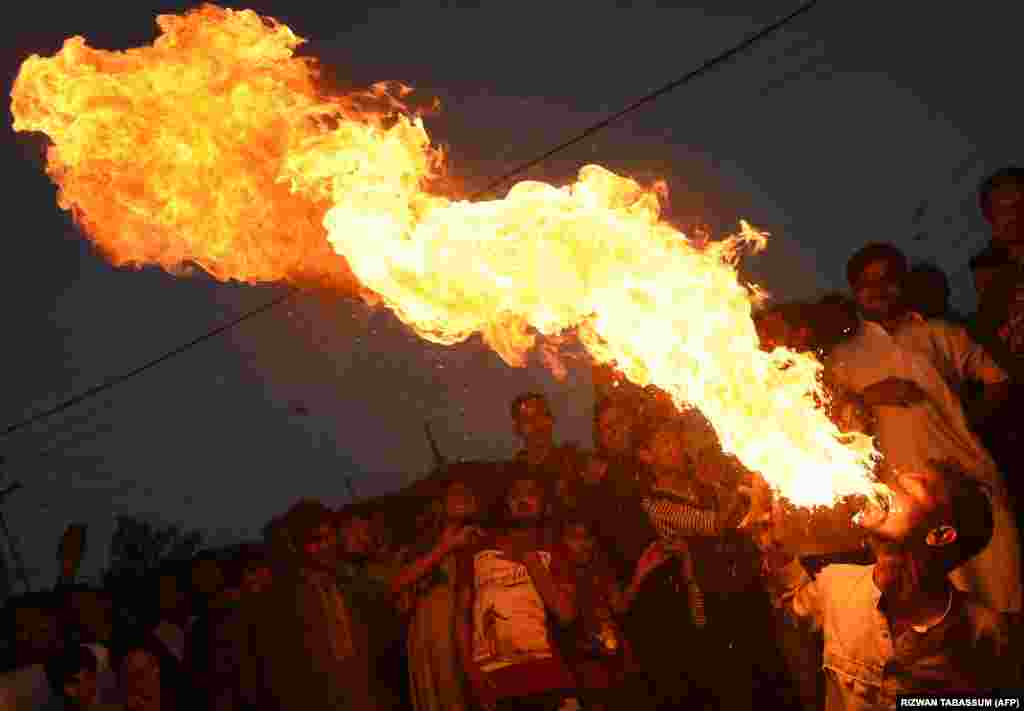 A Pakistani Sunni Muslim spits fire during an Ashura procession in Karachi. Ashura is a 10-day period of mourning in remembrance of the seventh-century martyrdom of the Prophet Muhammad&#39;s grandson Imam Hussein, who was killed in the battle of Karbala in modern-day Iraq, in 680 AD. (AFP/Rizwan Tabassum)