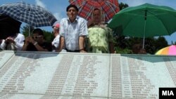 У памятной плиты с именами тысяч убитых. Мемориальный центр Поточари, где захоронены тысячи жертв массового убийства мусульман в Сребренице 11 июля 1995