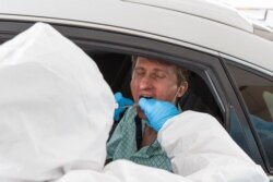 Дәрігерлер ер адамнан зерттеу сынамасын алып жатыр. Алматы, 14 мамыр 2020 жыл.